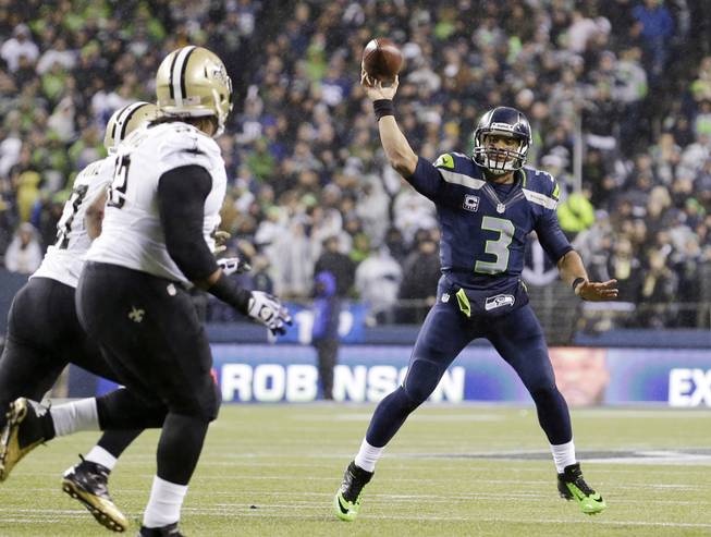 Seattle Seahawks quarterback Russell Wilson (3) throws against the New Orleans Saints in the first half of an NFL football game, Monday, Dec. 2, 2013, in Seattle.