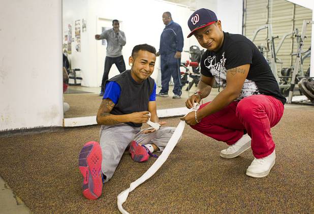 Boxer Yosigey Ramirez, 23, left, a graduate of Clark High School, prepares for a workout with his cousin Yoshimar Ramirez during a workout at the Pochiro Boxing gym Tuesday, Dec. 3, 2013.  Pochiro Boxing Promotions will hold a boxing card featuring local boxers at Sam's Town Friday.