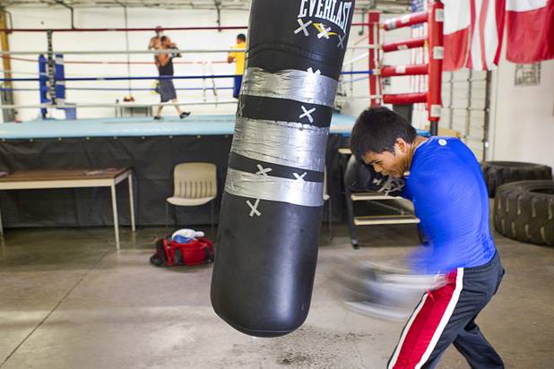 Amateur lightweight boxer Aurelio Moreno hits a heavy bag during a workout at the Pochiro Boxing gym Tuesday, Dec. 3, 2013. Pochiro Boxing Promotions will hold a boxing card featuring local boxers at Sam's Town Friday.