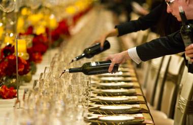 Wine is poured before guests arrive for La Cucina’s Grand Banquet at the Venetian on Friday Dec. 6, 2013.