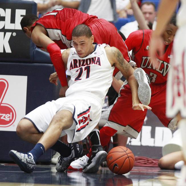 UNLV guard Bryce Dejean Jones and Arizona forward Brandon Ashley get tangled up during their game at the McKale Center in Tucson Saturday, Dec. 7, 2013. Arizona won the game 63-58.