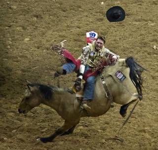 Bareback rider Ty Breuer holds tight during the Wrangler National Finals Rodeo Go-Round Day 3 at the Thomas & Mack Center in Las Vegas, Nevada, on Saturday,  Dec. 7, 2013.