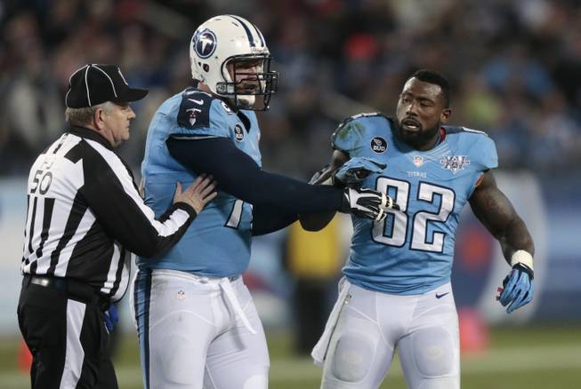 Tennessee Titans tight end Delanie Walker (82) is restrained by tackle Michael Roos, center, and field judge Mike Weir (50) during an altercation in the second quarter of an NFL football game between the Titans and the Indianapolis Colts on Thursday, Nov. 14, 2013, in Nashville, Tenn.