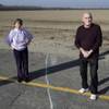 Phyllis and Ross Browning stand alongside a line drawn across Cairo Avenue marking the path of the proposed high-speed rail through their Hanford, Calif., neighborhood, Dec. 12, 2013. The proposed rail line will run a few houses away from their residence. The couple moved to Hanford in 2005 to retire and live next door to Phyllis' mother.