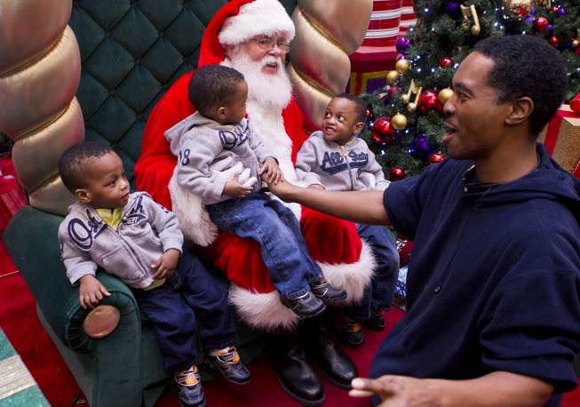 Deon Derrico and his sons visit with Santa during a Christmas gift shopping trip to the mall Friday, Dec. 13, 2013.