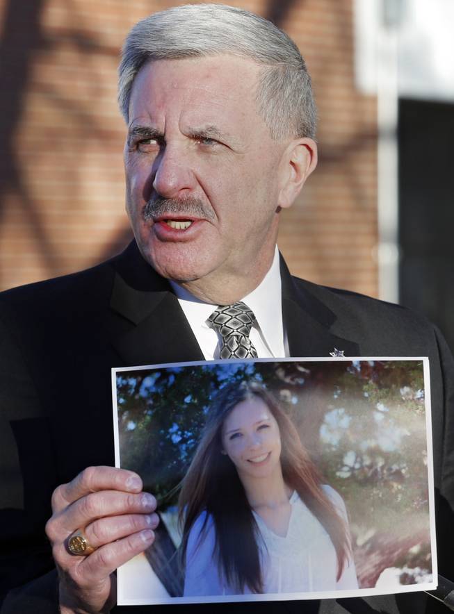 During a briefing Saturday, Dec. 14, 2013, at Arapahoe High School in Centennial, Colo., Arapahoe County Sheriff Grayson Robinson holds a picture of Claire Davis, the 17-year-old student who was shot by Karl Pierson at the school on Friday.