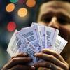 Chad Cuneo displays Mega Millions lottery tickets he purchased at a newsstand Friday, Dec. 13, 2013, in Philadelphia. 