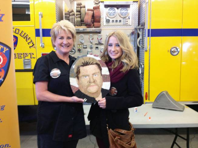 Jan Young and her daughter, Nikki Erwin, hold a floragraph of Paul Young, a longtime Clark County Fire Department captain who died suddenly last year but donated his organs. The floragraph will ride aboard a float in the 125th Rose Bowl Parade.