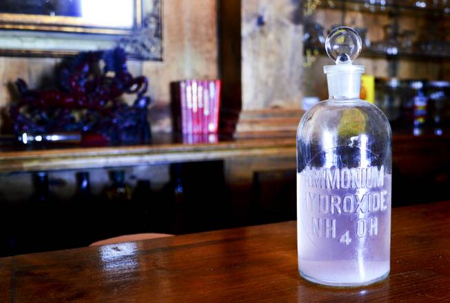 A bottle marked ammonium hydroxide, which was found on the grounds of the Belmont Inn and Saloon, sits on the bar. Believed to be from Belmont's early history, it was cleaned and filled with colored water.
