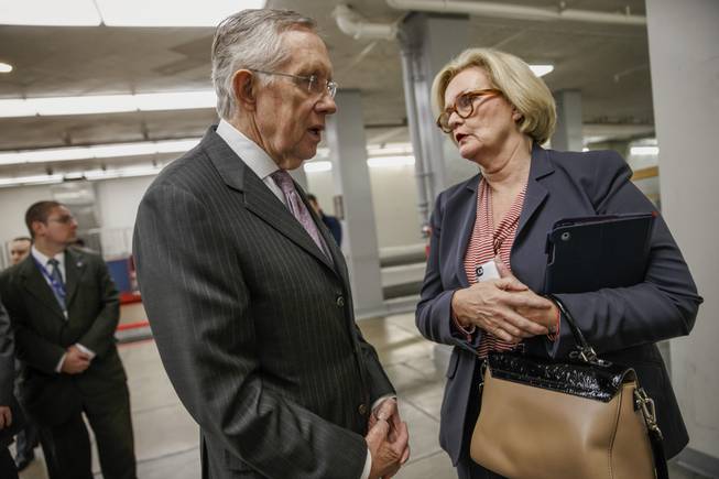 Senate Majority Leader Harry Reid speaks to Sen. Claire McCaskill, D-Mo., right, on Capitol in Washington, Tuesday, Dec. 17, 2013, as lawmakers come and go from the Senate after a bipartisan budget compromise cleared a procedural hurdle, advancing past a filibuster threshold on a 67-33 vote that ensures the measure will pass the Democratic-led chamber no later than Wednesday and head to the White House to be signed into law.