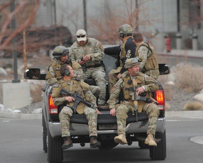 SWAT team members are trucked from near the Renown helicopter pad to Renown Medical Center, where a lone gunman shot and injured four people before killing himself at a sprawling medical campus Tuesday, Dec. 17, 2013 in Reno, Nev.