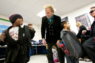 Kenneth Williams, left, smiles after receiving a backpack full of goodies from Siegfried and Roy during the holiday party provided at the Boys and Girls Club at 2801 E. Stewart Avenue in Las Vegas December 20, 2013.