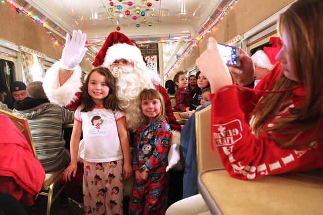 Grace, left, and Elliana Carafelli pose for a photo with Santa during the Nevada Southern Railway's "Pajama Train" ride Saturday, Dec. 21, 2013.