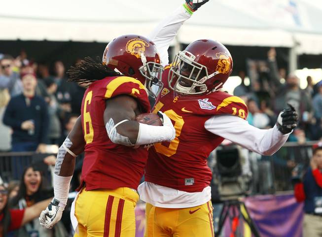 USC safeties Josh Shaw and Dion Bailey celebrate Shaw's interception of a Fresno State pass during the Royal Purple Las Vegas Bowl Saturday, Dec. 21, 2013 at Sam Boyd Stadium. USC won the game 45-20.