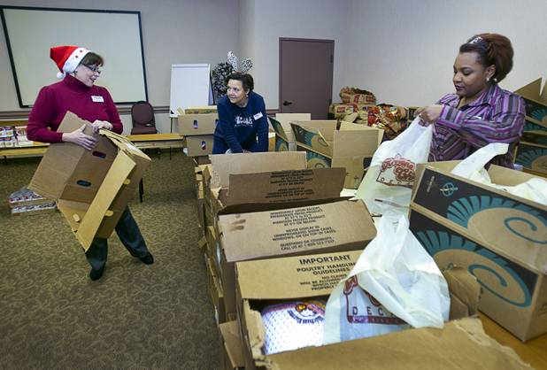 Arizona Charlie's employees, from left, Andrea Dempsey, Debbi Lewis, and Jenesha Hawthorne pack holiday food boxes at the Boulder Highway location Monday, Dec. 23, 2013. Casino patrons contributed loyalty card points to the Feed a Family program and bought holiday dinners for 60 families. The food baskets will be picked up by the Southern Nevada Regional Housing Authority for distribution to needy families.