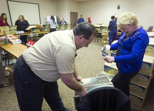 Arizona Charlie's employees John Arto and Debbie Pingul pack holiday food boxes at the Boulder Highway location Monday, Dec. 23, 2013. Casino patrons contributed loyalty card points to the Feed a Family program and bought holiday dinners for 60 families. The food baskets will be picked up by the Southern Nevada Regional Housing Authority for distribution to needy families.