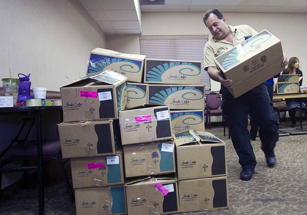 John Arto, Arizona Charlie's chief engineer, stacks holiday food boxes at the Boulder Highway location Monday, Dec. 23, 2013. Casino patrons contributed loyalty card points to the Feed a Family program and bought holiday dinners for 60 families. The food baskets will be picked up by the Southern Nevada Regional Housing Authority for distribution to needy families.