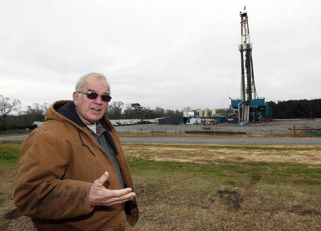 In this Monday, Dec. 23, 2013, photograph, Amite County Supervisor Max Lawson describes the convoy of about 200 trucks carting in a drilling rig and other gear on what was pasture land at his Gillsburg, Miss., farm. After a little more than a two-year wait, Encana Corp. contractors were finally drilling.