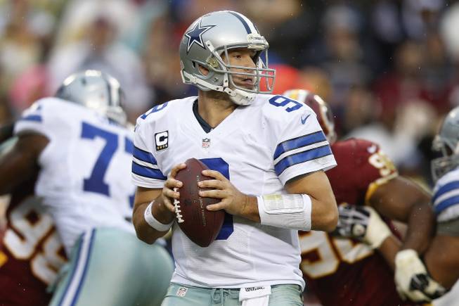 Dallas Cowboys quarterback Tony Romo looks for an opening to pass during the second half of an NFL game against the Washington Redskins in Landover, Md., on Sunday, Dec. 22, 2013.