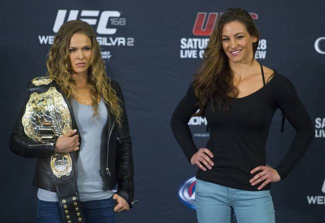 Ronda Rousey and Miesha Tate pose near the end of a press conference for the upcoming UFC168 at the MGM Grand Hotel & Casino with commentary from the top fighters on the card Thursday,  Dec. 26, 2013.