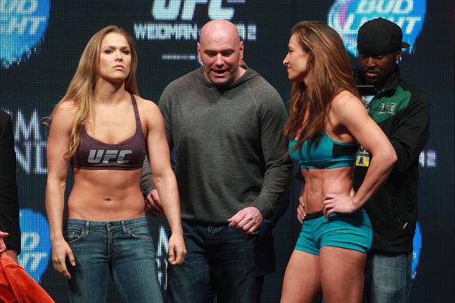 Ronda Rousey and Miesha Tate pose after facing off during the weigh in for UFC 168 Friday, Dec. 27, 2013, at the MGM Grand Garden Arena.