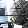 With members of the media gathered, at left, a Waterford crystal triangle is installed on the New Year's Eve Ball by Landmark Signs workers, right, Friday, Dec. 27, 2013 on the roof of One Times Square in New York. 