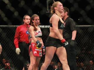 Miesha Tate extends her hand to shake Ronda Rousey's after Rousey submitted Tate with an arm bar to successfully defend her bantamweight title at UFC 168 Saturday, Dec. 28, 2013 at the MGM Grand Garden Arena.