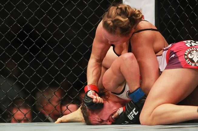 Ronda Rousey pounds on Miesha Tate during their fight at UFC 168 Saturday, Dec. 28, 2013 at the MGM Grand Garden Arena. Rousey won via tap out with an arm bar.
