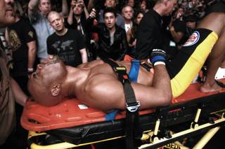 Anderson Silva is wheeled out on a stretcher after breaking his leg during the second round of his middleweight title fight against Chris Weidman at UFC 168 Saturday, Dec. 28, 2013 at the MGM Grand Garden Arena in Las Vegas.
