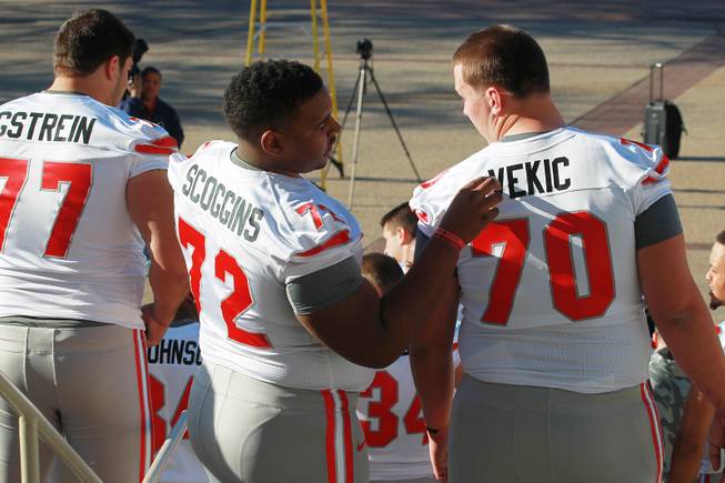 Las Vegas natives and UNLV linemen Ron Scoggins checks the lettering on teammate Aleks Vekic before having their team photo taken for the Heart of Dallas Bowl Tuesday, Dec. 31, 2013 at the Cotton Bowl in Dallas.