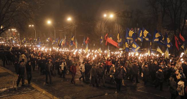 Ukrainian nationalists carry torches during a rally in downtown Kiev, Ukraine, late Wednesday, Jan. 1, 2014. The rally was organized on the occasion of the birth anniversary of Stepan Bandera, founder of a rebel army that fought against the Soviet regime and who was assassinated in Germany in 1959. 