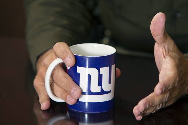 Sheriff Doug Gillespie, originally from a small town in upstate New York, holds a mug with a New York Giants logo during an interview at his office in Metro Police Headquarters Thursday, Jan. 2, 2014.