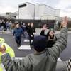A small group of machinists union members are greeted by a supporter as they march away from a Boeing factory building toward the machinists' union hall in Everett, Wash., Dec. 18, 2013.