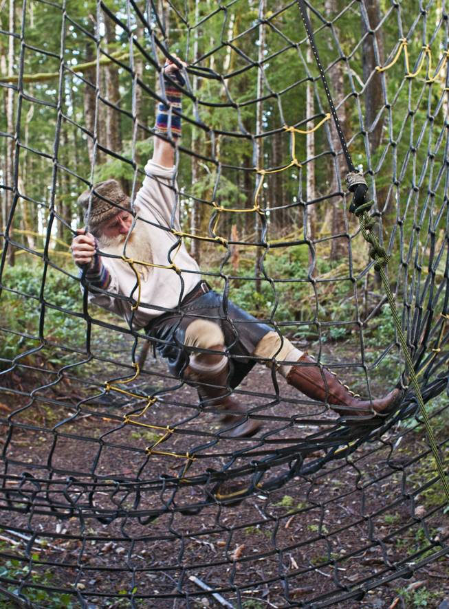 Mick Dodge climbs a cargo net at his cabin along the Sol Duc River near Forks, Wash., on January 3, 2014.