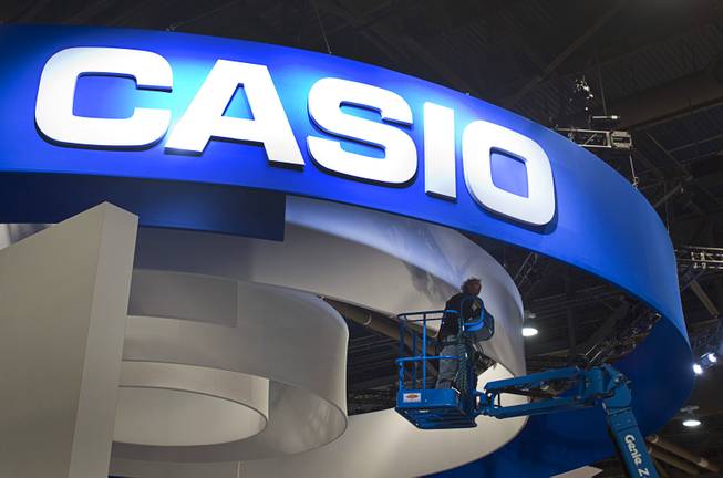 A worker checks on lights at a Casio booth during set up  for the 2014 Consumer Electronics Show (CES) at the Las Vegas Convention Center Saturday, Jan. 4, 2014.