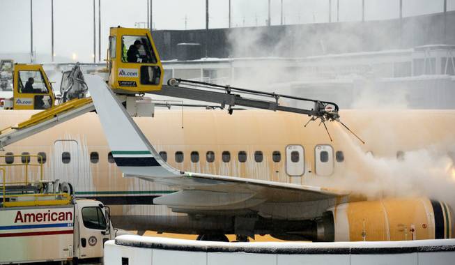 Crews work to de-ice planes at O'Hare International Airport in Chicago on Sunday, Jan. 5, 2014. Temperatures not seen in years are likely to set records in the coming days across the Midwest, Northeast and South, creating dangerous travel conditions and prompting church and school closures.