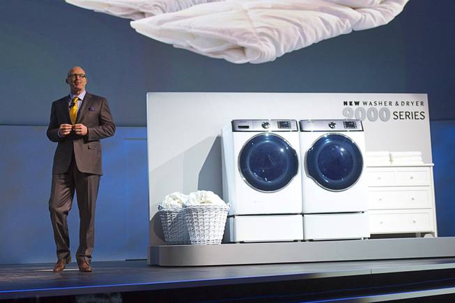 Kevin Dexter, senior vice president of Samsung Electronics America, shows off the 9000 Series clothes washer and dryer during the International Consumer Electronics Show (CES), in Las Vegas, Monday Jan. 6, 2014. The 9000 Series is the world's largest washer and dryer, Dexter said.