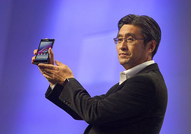 Kunimasa Suzuki, president/CEO of Sony Mobile Communications, displays a Sony XperiaZ1s smartphone during a Sony news conference at the International Consumer Electronics Show (CES), in Las Vegas, Monday Jan. 6, 2014. The Xperia Z1s will be available exclusively through T Mobile and be available nationwide on january 22, he said.