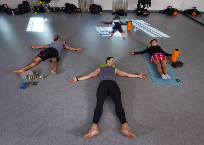 (Clockwise from front) Instructor Mark Coronel leads  Montel Coronel, Joycelyn Nicholas and Ricki Halling in a Trigger Point class at TruFusion Yoga on Monday, Jan. 6, 2014.