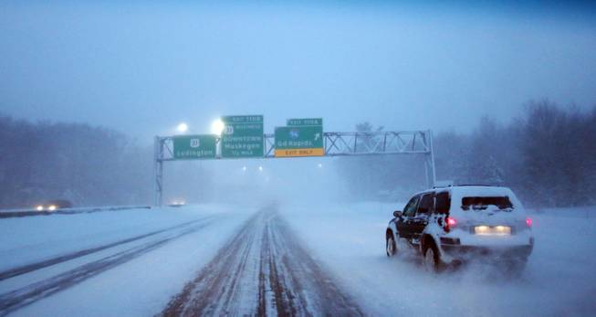 Motorists navigate northbound U.S. 31 near the I-96 exit in blowing snow and sub-zero conditions Monday morning, Jan. 6, 2014, near Norton Shores, Mich. A whirlpool of frigid, dense air known as a "polar vortex" descended Monday into much of the U.S.