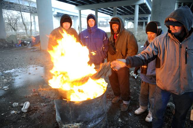 Michael Best, right, and others who identified themselves as homeless use donated wood and a fire barrel to keep warm Monday, Jan. 6, 2014, in Knoxville, Tenn. Monday's expected high temperature in Knoxville of around 24 degrees came hours before dawn, and is expected to fall into the single digits for most of East Tennessee.