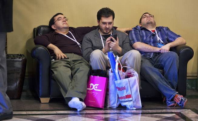 (From left) Erwin,  Sean and Jonathan Quinonez of West Jordan, Utah, do their best to relax after a long day of CES at the Las Vegas Convention Center on Wednesday, Jan. 8, 2014.