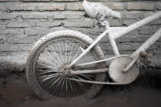A bicycle is caked with volcanic ash from the eruption of Mount Sinabung outside a house in Sibintun, North Sumatra, Indonesia, Tuesday, Jan. 7, 2014. 