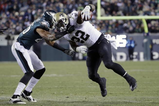New Orleans Saints' Mark Ingram (22) tries to break free of Philadelphia Eagles' Cary Williams during the second half of an NFL wild-card playoff football game, Saturday, Jan. 4, 2014, in Philadelphia.