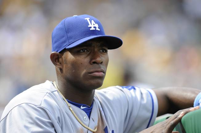 In this June 16, 2013, photo, Los Angeles Dodgers' Yasiel Puig watches from the dugout during a game against the Pittsburgh Pirates in Pittsburgh. Twenty-five Cuban-born players appeared in the major leagues this year, a group that includes outfielders Puig and Yoenys Cespedes, and hard-throwing reliever Aroldis Chapman.