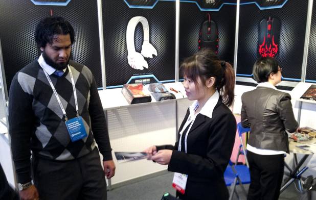 Lei Zhang of Shenzhen Suoai Electronics and Technology, Shenzhen, China, gives product literature to a customer at her 2014 CES booth Wednesday, Jan. 8, 2014, at the Venetian.
