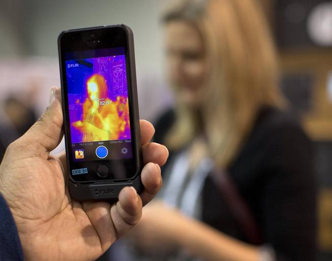 The FLIR ONE thermal imager for the iPhone is demonstrated at the International Consumer Electronics Show, Thursday, Jan. 9, 2014, in Las Vegas. The imager attaches to the back of an iPhone 5 or 5s and translates heat data into color images on the phone's screen.
