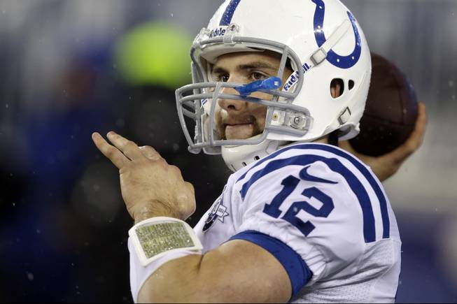 Indianapolis Colts quarterback Andrew Luck warms up in the rain before an AFC divisional NFL playoff football game against the New England Patriots in Foxborough, Mass., Saturday, Jan. 11, 2014.