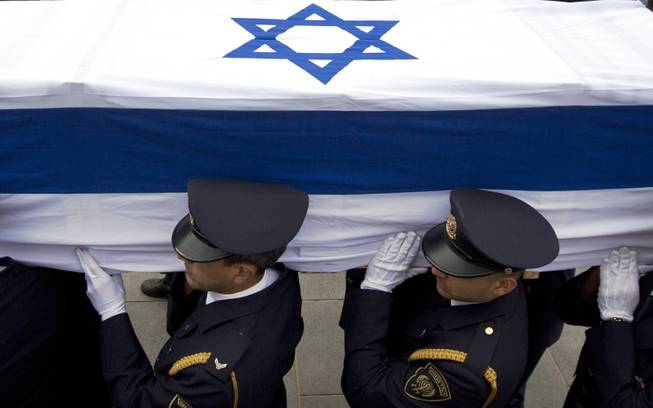 Members of the Knesset guard carry the coffin of late Israeli Prime Minister Ariel Sharon at the Knesset, Israel's Parliament, in Jerusalem, Sunday, Jan. 12, 2014. 