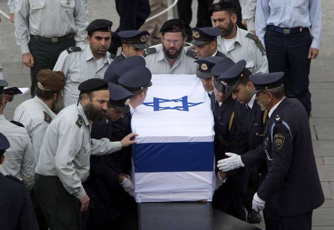 Members of the Knesset guard carry the coffin of former Israeli Prime Minister Ariel Sharon at the Knesset plaza, in Jerusalem, Sunday, Jan. 12, 2014. 